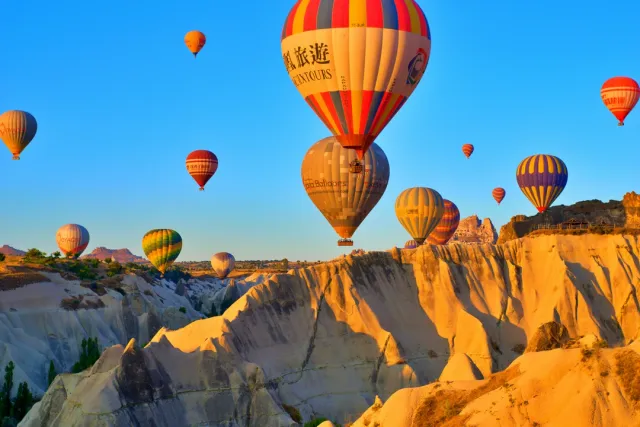Hot air balloons over fairy chimneys, underground cities and Göreme Open‑Air Museum. We arrange cave‑hotel stays and sunrise balloon experiences.
