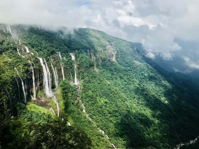 Living root bridges of Nongriat—nature's architectural marvel. Seven Sisters Falls, Nohkalikai Falls, and Mawsmai Caves. We arrange guided treks with local storytellers to bring the hills alive.