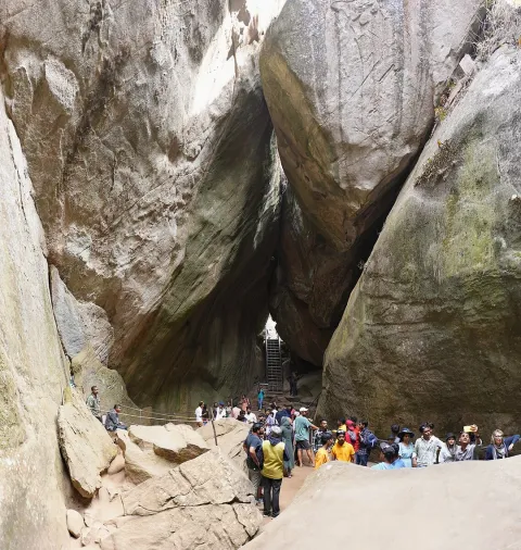 Tourists gather inside the Edakkal Caves in Kerala, a natural fissure between giant boulders famous for its prehistoric rock carvings