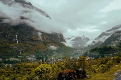 The remote village of Lachung nestled deep in a valley, surrounded by towering, cloud-shrouded Himalayan peaks in North Sikkim