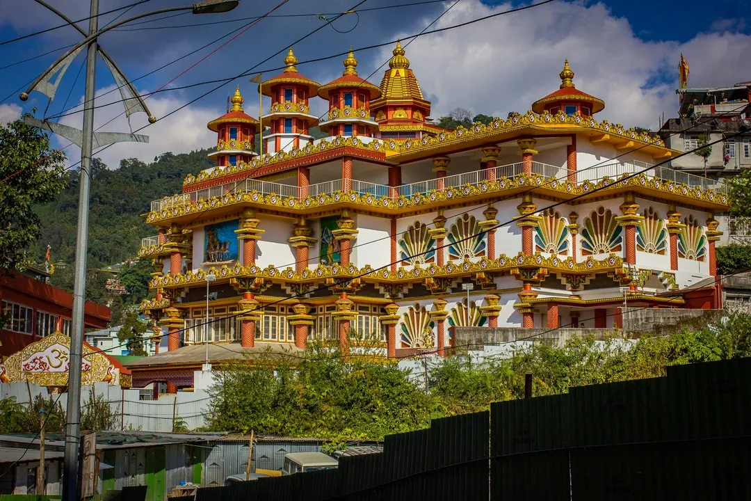 The ornate, multi-storied building of the Ranka Monastery, showcasing its golden roofs and vibrant, traditional Buddhist architecture