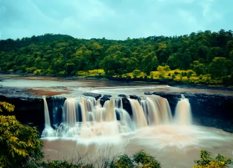 Gira Waterfalls cascading amid lush greenery