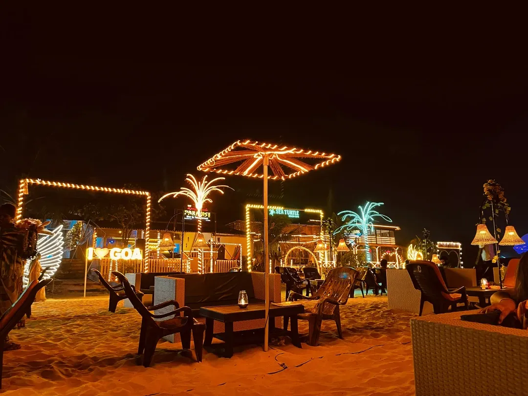 Nightlife at a Goa beach shack with glowing lights, palm decor, and sandy seating