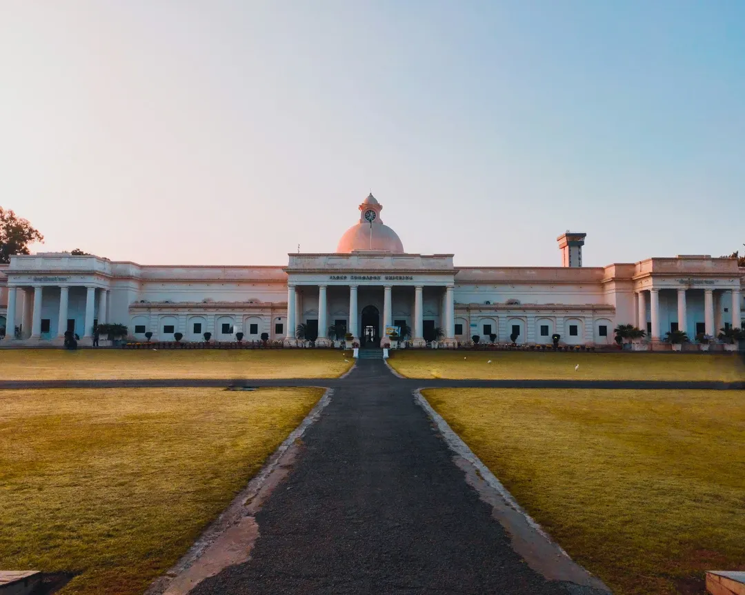 White domed museum building with broad lawn in front at golden hour