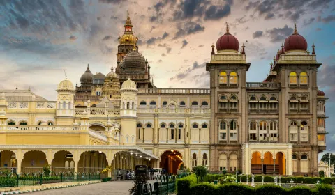 Mysore Palace (Amba Vilas Palace) at Sunset The grand Mysore Palace in Mysuru, with its ornate domes and arches glowing under a dramatic evening sky