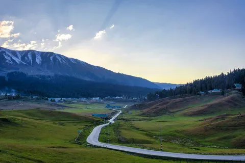 The iconic yellow cable cars of the Gulmarg Gondola glide over a vast, snow-covered mountain landscape in Kashmir