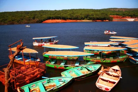 Colorful rowboats and paddle boats on the calm waters of Venna Lake, a popular tourist attraction in the hill station of Mahabaleshwar